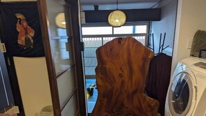Ein Zimmer mit einer großen Holzskulptur, einer Waschmaschine und einer traditionellen japanischen Schiebetür.