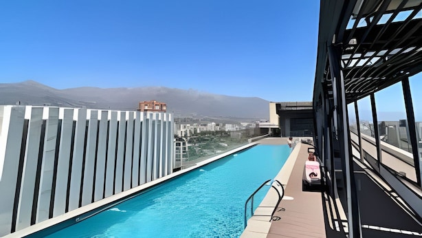 A rooftop pool with a clear view of the cityscape and mountains in the background. - Comfortable, equipped stay in a prime area (Las Condes)