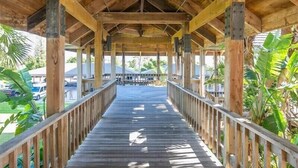 A wooden covered walkway with a view of a building in the background.