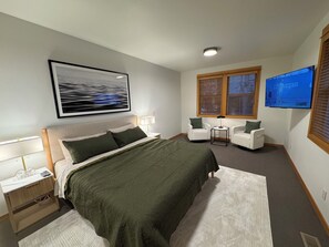 A bedroom with a bed, two chairs, a TV, and a painting on the wall. - Family Friendly Fremont Crossing Home, 3 Kings, Bunk Room, Hot Tub, SHARC Passes (Sunriver)