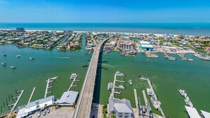 An aerial view of a coastal marina with multiple docks, boats, and buildings.