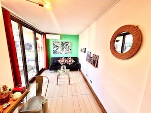 A modern living room with a sofa, coffee table, and artwork on the walls. - Las Condes Apt | Prime Location + Fully Equipped (Las Condes)