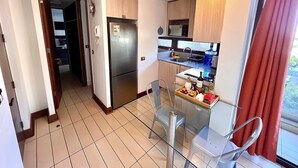 A compact kitchen with a refrigerator, microwave, and sink. - Las Condes Apt | Prime Location + Fully Equipped (Las Condes)