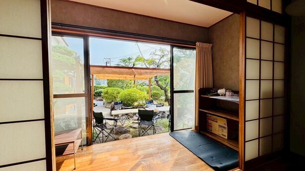 A traditional Japanese room with tatami flooring, a sliding glass door leading to an outdoor garden, and a wooden shelf with items on it. - Fumiko-no-tei Residence with a view of the sea Max. 17 - 34 people OK. garden BBQ (西牟婁郡白浜町)