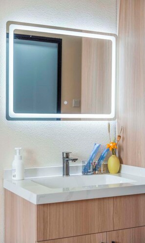 Cubrecamas, espacio para trabajar con laptop y cortinas blackout