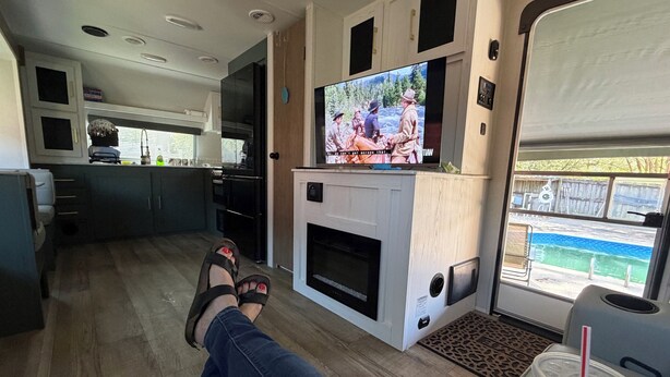 A living area with a TV, a fireplace, and a view of a swimming pool. - Convenient to UA, Northport and Mercedes (Tuscaloosa)