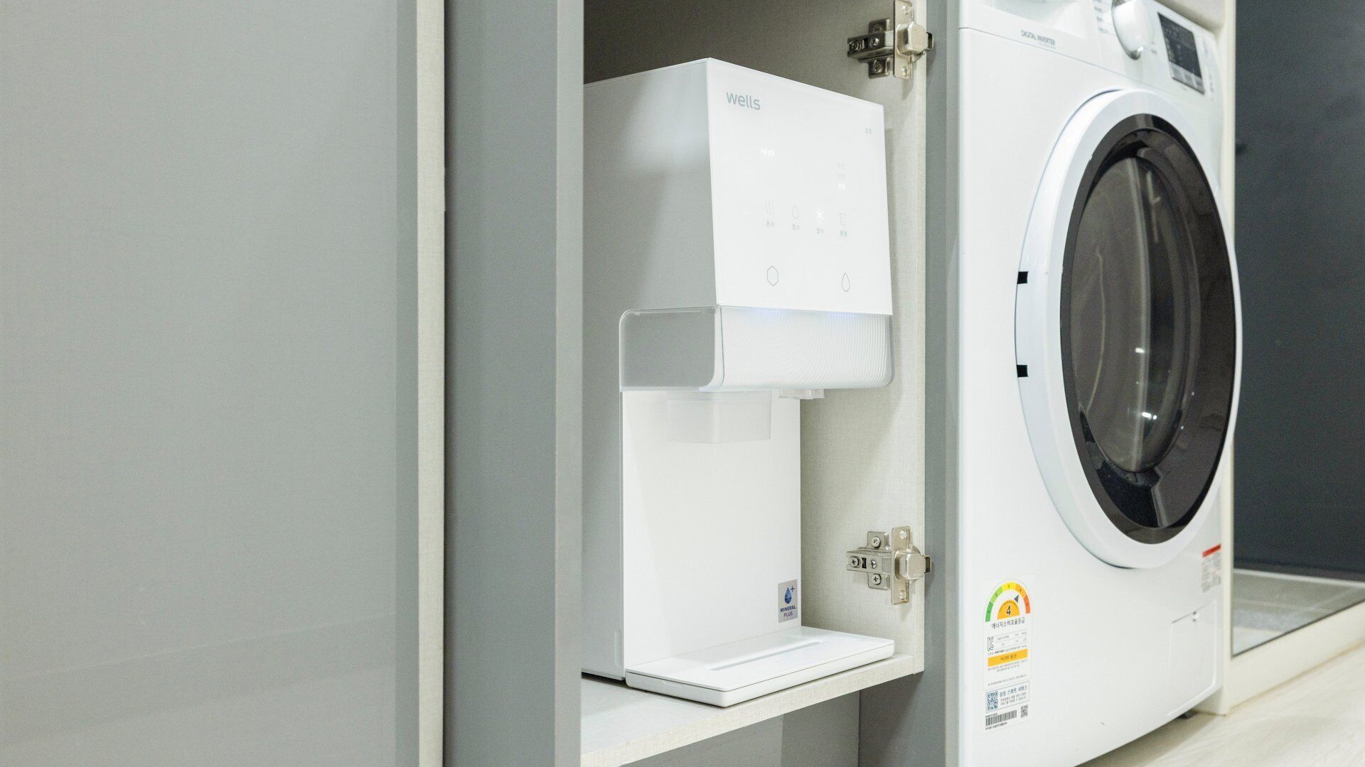Een witte wasmachine met bedieningspaneel en een waterafgifte-unit.