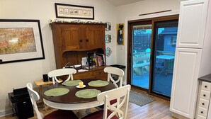 A dining area with a round table, white chairs, and a wooden cabinet. - Welcome FIFA! Nice 4-BR house, EZ Access to stadiums, PHL Airport, I95 & Transit (Claymont)