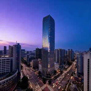 A high-rise building with a modern glass facade, surrounded by other tall buildings and busy streets.