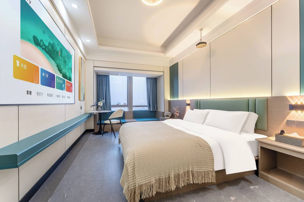 Un hotel moderno con una cama grande, un escritorio y vistas a la ciudad.