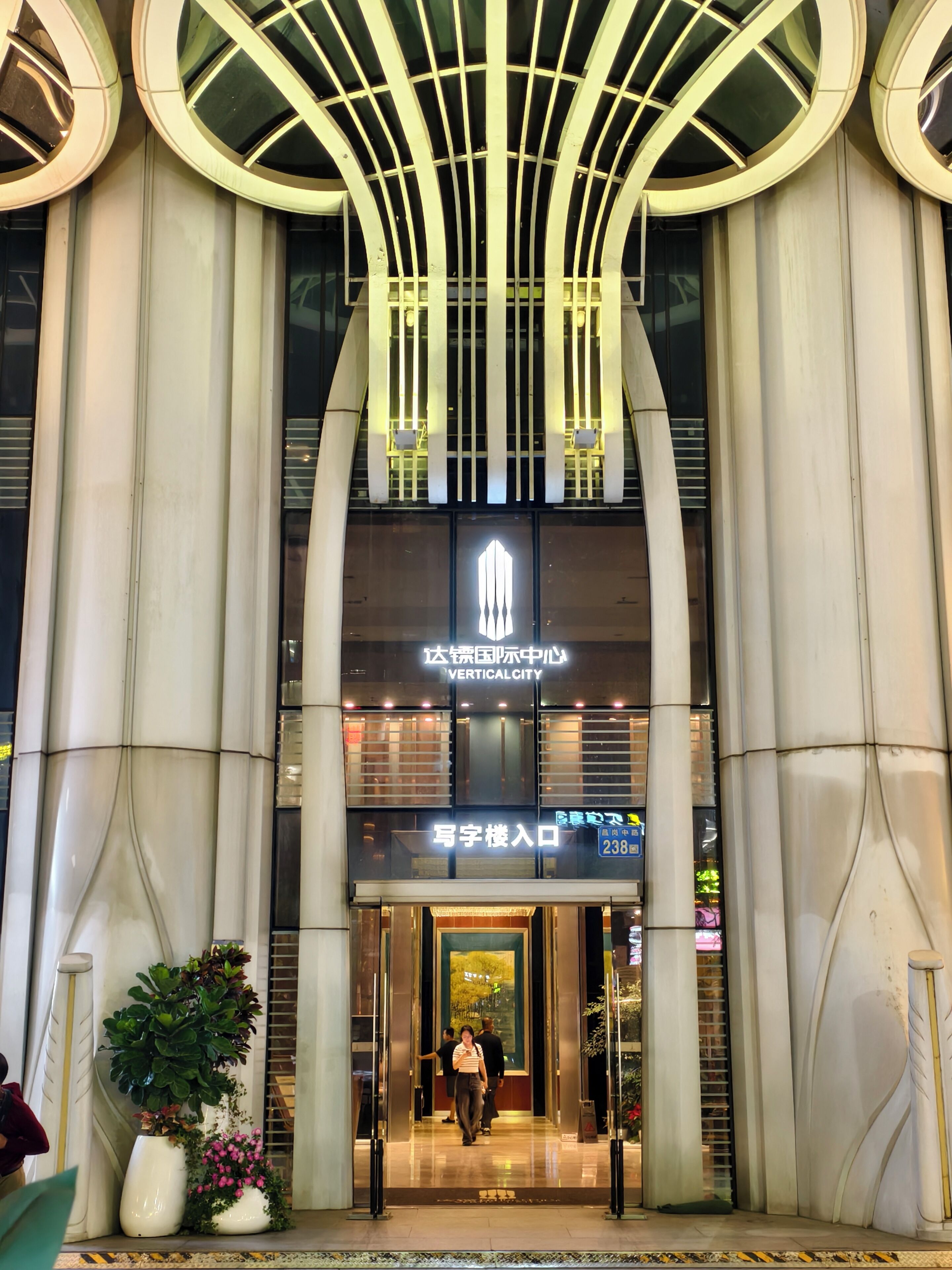 Un edificio moderno con una entrada destacada, amplias columnas y un diseño de techo distintivo.