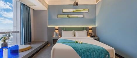 A modern hotel room with a large bed, a view of the city, and a balcony with a blue chair.