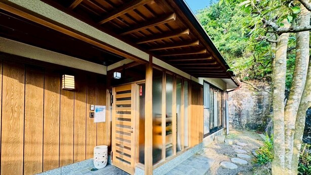 A traditional wooden building with a covered entrance and a stone pathway leading to a natural setting. - Fumiko-no-tei Hanare 1 minute walk to the sea 17 - 34 people OK 4 bedrooms 2 toilets (西牟婁郡白浜町)