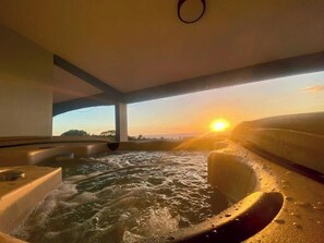 Een bubbelbadgedeelte met uitzicht op de ondergaande zon.