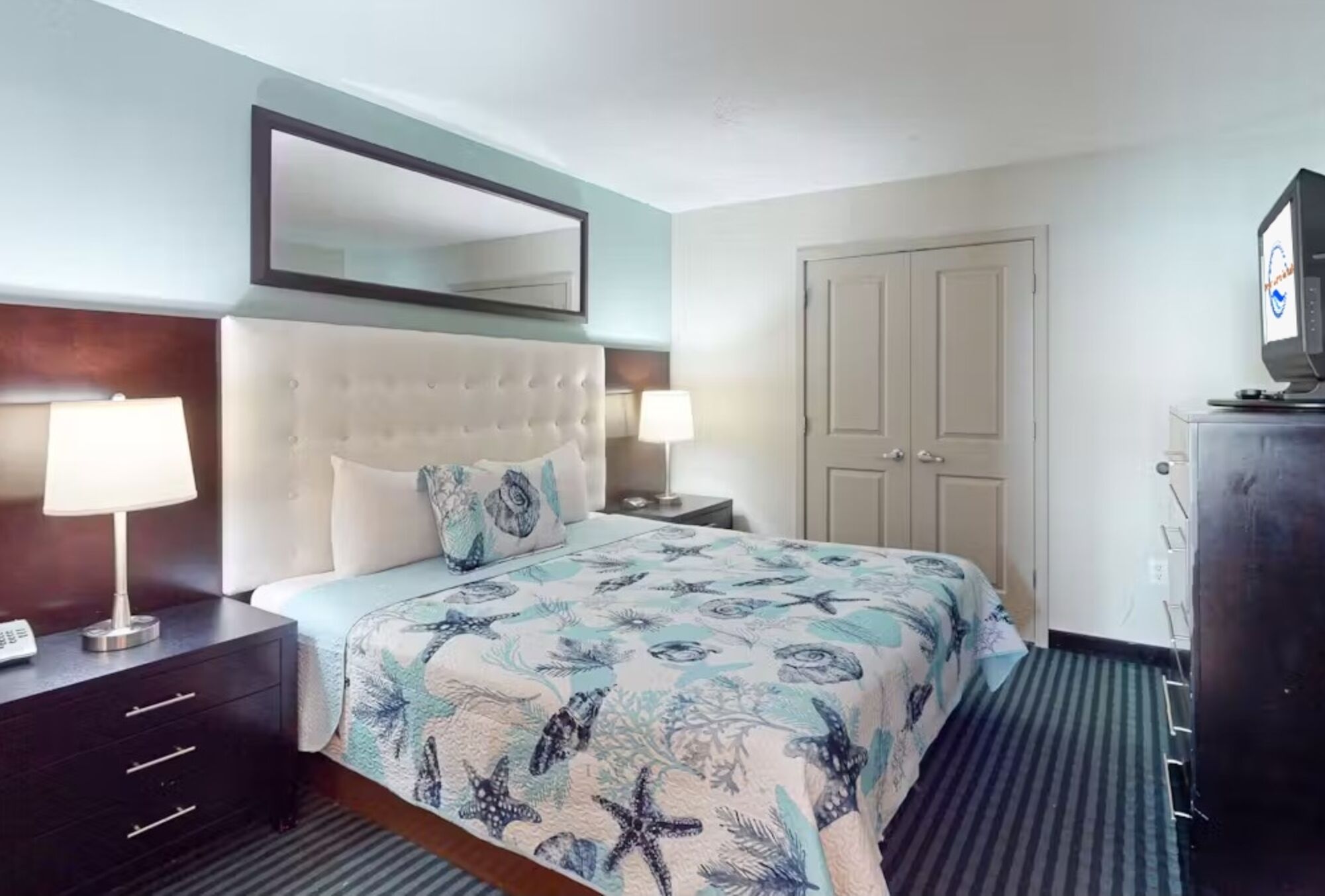 Clean modern bedroom with cozy bedding, Tv and a relaxing sleep environment