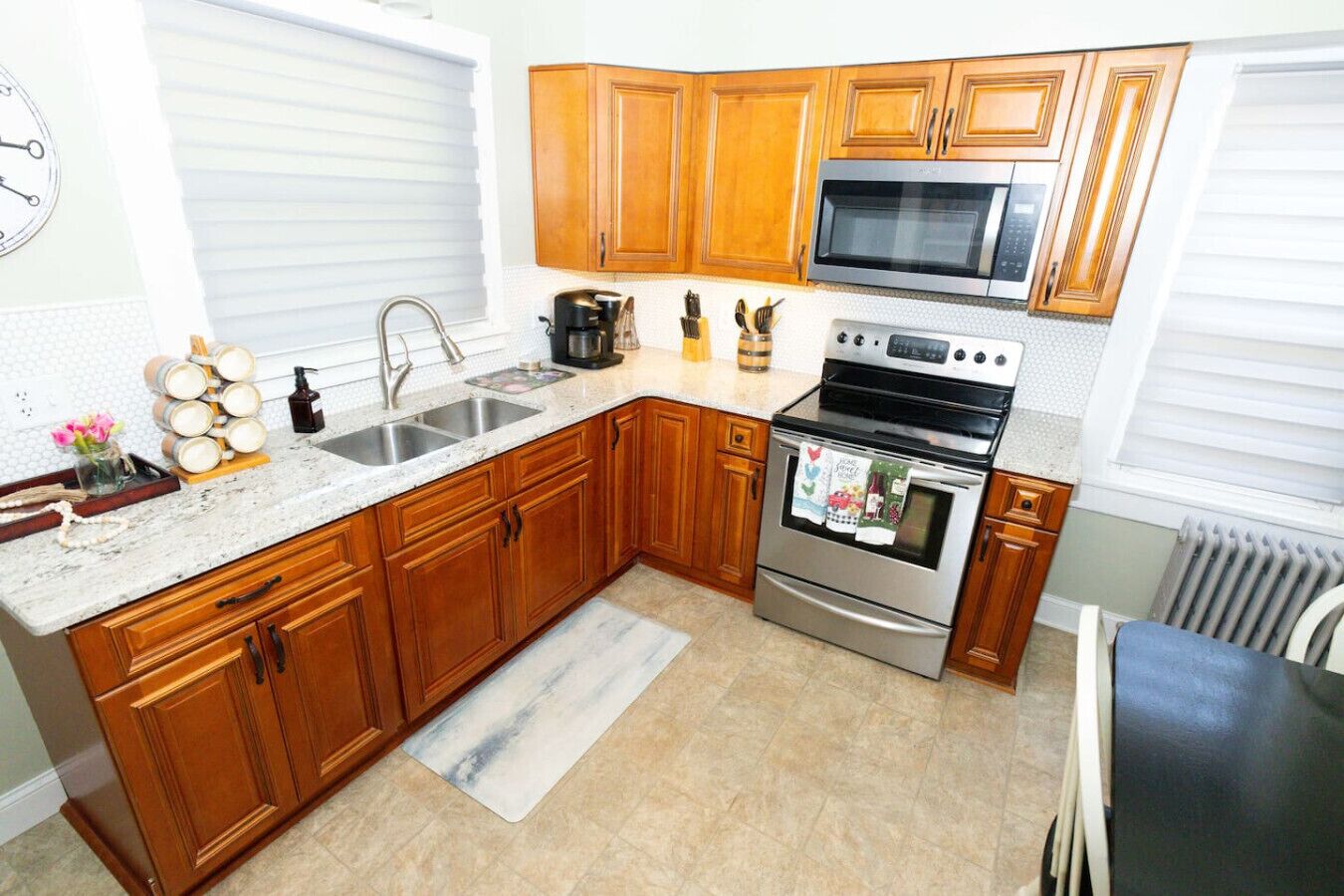 A modern kitchen with wooden cabinets, stainless steel appliances, and a granite countertop.
