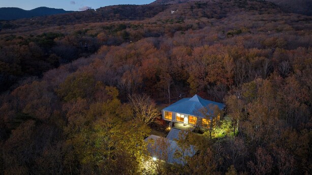 A modern house with a blue roof surrounded by autumn-colored trees. - NASU PRIVATE FOREST (Nasu)