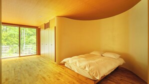 A bedroom with a wooden floor, a bed, and a large window with a view of greenery. - NASU PRIVATE FOREST (Nasu)