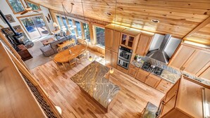Una cabaña espaciosa con un amplio comedor, pisos de madera y una cocina equipada con electrodomésticos modernos.
