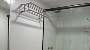 Een moderne badkamer met een wit toilet, een granieten aanrechtblad en een douchecabine van glas.