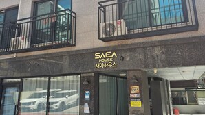 Ein Gebäude mit einem Schild, auf dem „SSEA HOUSE“ steht, und einem sichtbaren Eingang.
