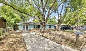 A single-story house with a front porch, a driveway, and a mailbox.