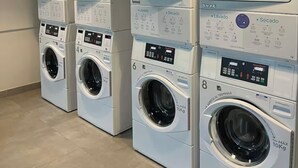 A row of stacked front-loading washing machines in a commercial setting. - Modern studio in downtown Bogota (Bogotá)