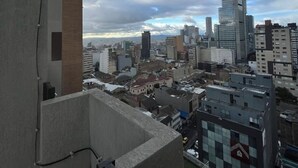 A cityscape with a prominent skyscraper, various buildings, and a cloudy sky. - Modern studio in downtown Bogota (Bogotá)