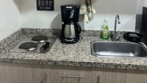 A kitchen with a microwave, coffee maker, sink, and granite countertop. - Modern studio in downtown Bogota (Bogotá)