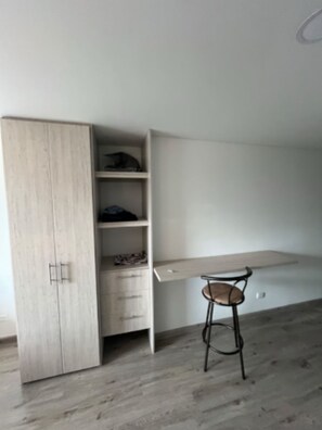 Une pièce comprenant un bureau intégré, une chaise et une armoire.