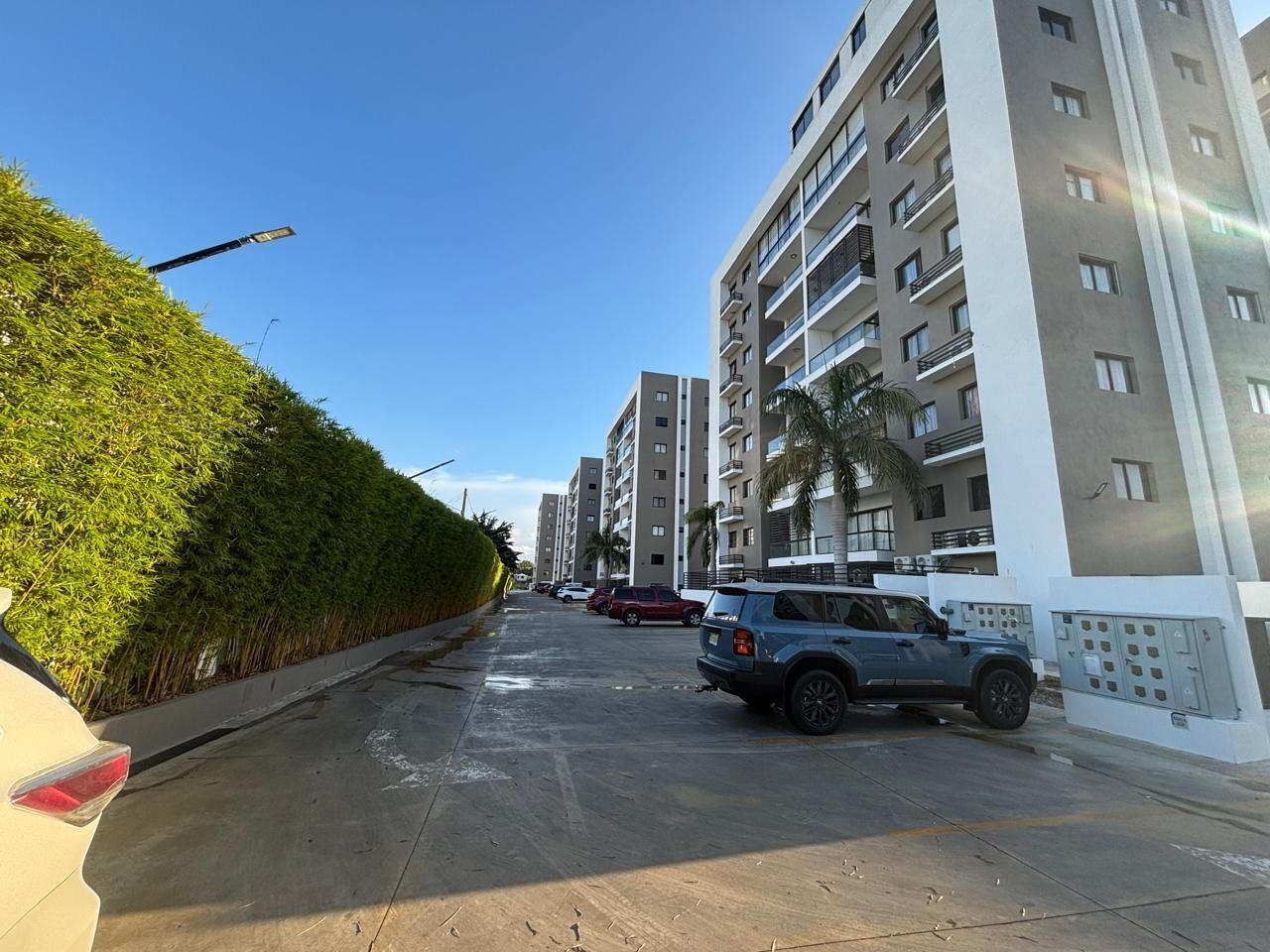 Un moderno edificio de apartamentos con varios pisos, balcones y cielo despejado.
