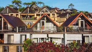 A row of residential buildings with pitched roofs and balconies, surrounded by lush greenery. - Bedugul Lake View Inn (Baturiti)