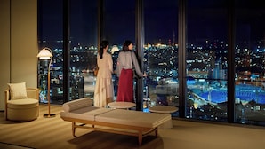 A modern hotel room with a large panoramic window, a sofa, a small round table, and a floor lamp. - OMO5 Yokohama Bashamichi by Hoshino Resorts (Yokohama)
