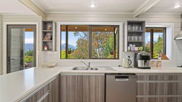 A modern kitchen with a built-in dishwasher, a double sink, and wooden cabinets.