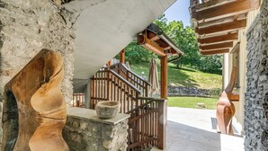 A wooden staircase leading to a stone wall, a wooden bench, and a garden view. - Relax In Pineta Beaulard, Oulx, Italy (Oulx)