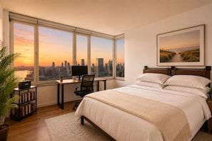 A bedroom with a city view, a desk with a computer, and a bed with multiple pillows. - Luxury 2BR/2BA Apartment with Stunning NYC Skyline Views (New York)