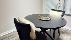 A dining area with a round table, two chairs, and two framed pictures on the wall. - Modern Executive Suite- NRG, Medical Center, Downtown Houston (Houston)