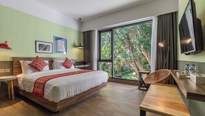 Una camera d'albergo con un letto grande, una scrivania, una sedia e una televisione.