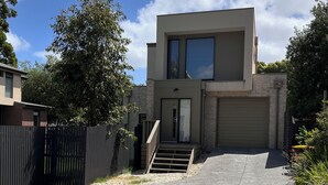 A modern two-story house with a garage, a front entrance with steps, and a driveway. - Natural, quiet, central home for your easy & comfortable trip to Frankston. (Frankston)