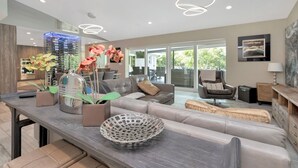 A modern living room with a sofa, coffee table, and decorative items. - Papys Preserve | Luxury Waterfront Estate w/ Pool (St Petersburg)