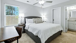 A bedroom with a bed, bedside tables, a desk, a ceiling fan, and a window with blinds. - Clemson Weekend Rental- very close to campus, 4 Bedroom 3 Bathroom (Clemson)