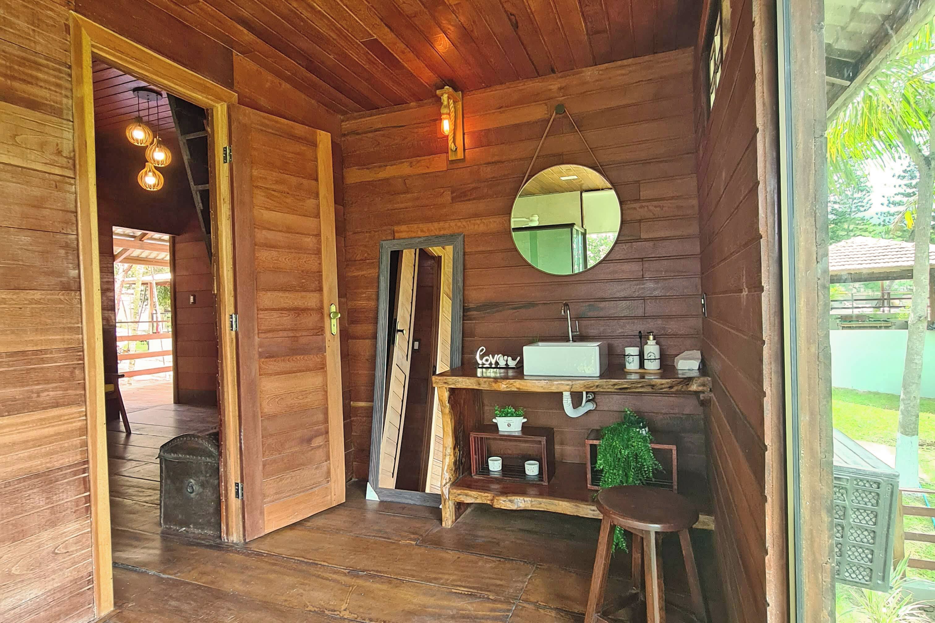 Un interior de madera con un banco, un espejo y una pequeña mesa con una radio.