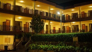 A multi-story hotel with balconies, staircases, and a well-lit exterior. - Tripletree Ken Hotel (Cisarua)