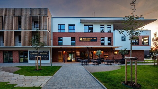 A modern building with a sign for "Tennis Resort & Hotel Break."