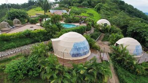 A resort with dome-shaped accommodations surrounded by lush greenery and a swimming pool. - Kintiri Glamping (Belen de Nosarita)