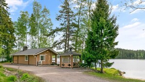 A cabin with a gravel driveway, a small porch, and a lake view. - Hiekkaranta by Interhome (Pertunmaa)