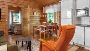 A cozy cabin interior with a dining area, kitchen, and a living room. - Hiekkaranta by Interhome (Pertunmaa)