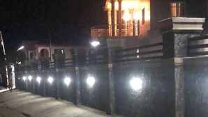 A nighttime view of a building with a lit balcony and a well-lit pathway. - international royal hotel (Owerri)