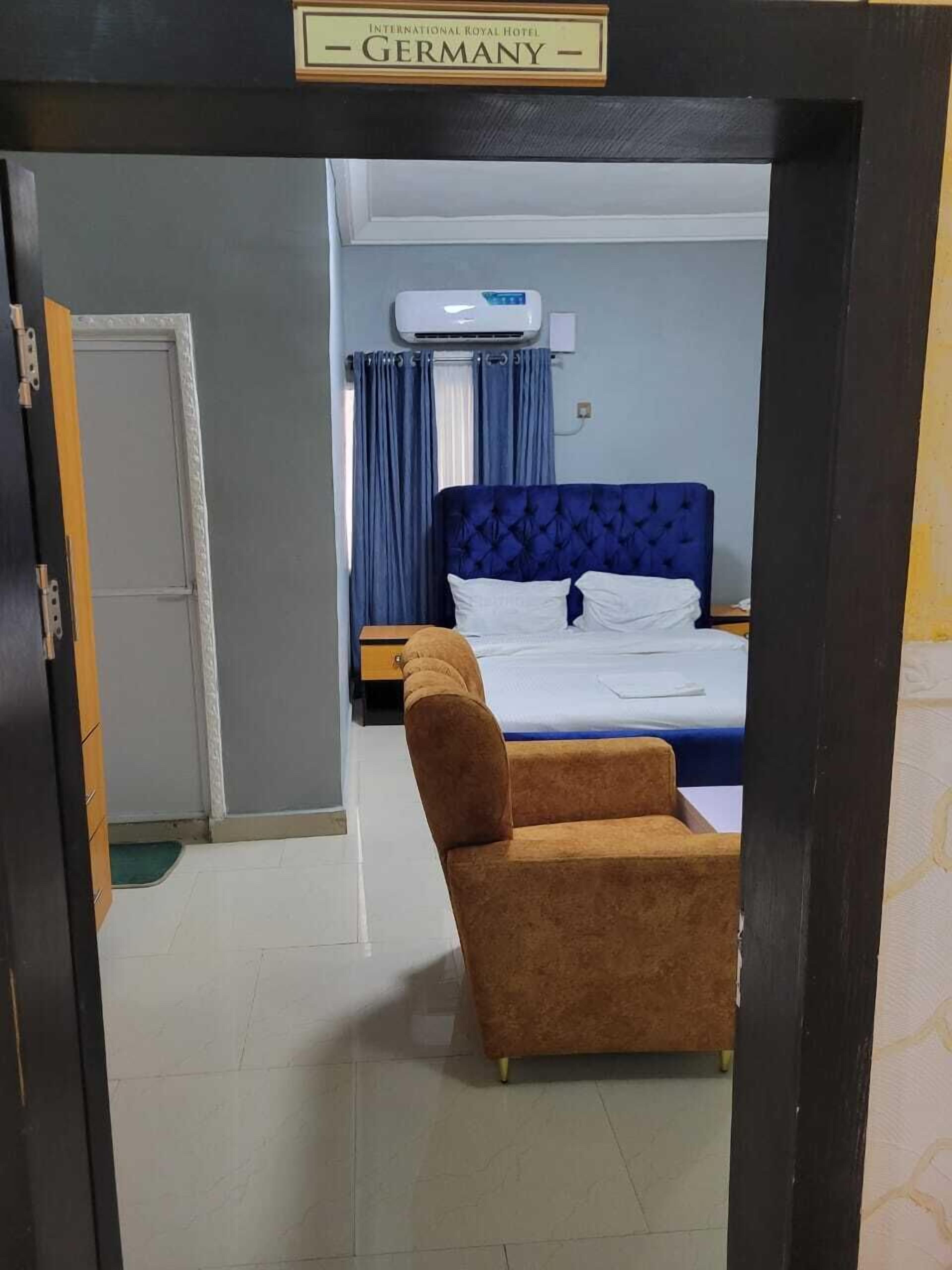 Une chambre d’hôtel avec un lit, une chaise et un appareil de climatisation.
