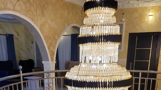 A grand chandelier in a spacious, well-lit room with a high ceiling and marble walls. - international royal hotel (Owerri)